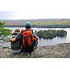 Parent and child sitting on cliff edge enjoying scenic view