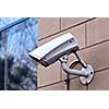 Security video camera on outside wall of a building
