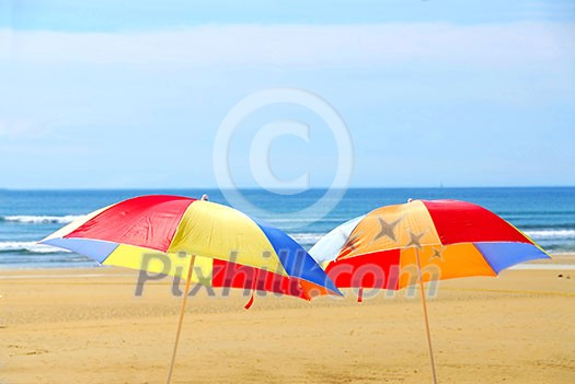 Two beach ubrella standing on ocean shore Two beach ubrella standing on ocean shore