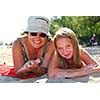 Grandmother and granddaughter relaxing on a sandy beach