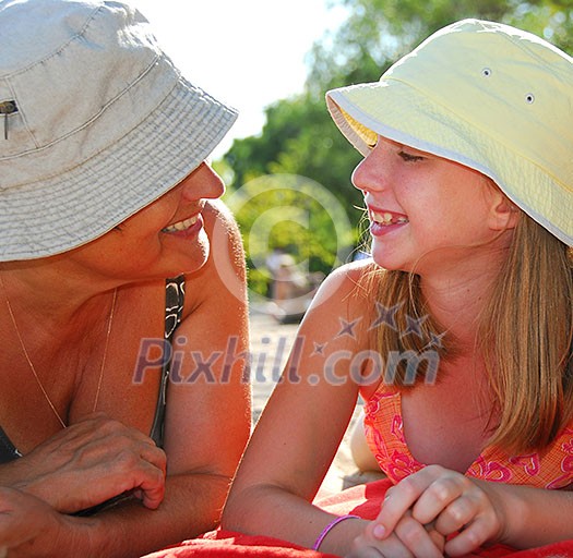 Grandmother and granddaughter relaxing on a sandy beach Grandmother and granddaughter relaxing on a sandy beach