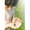 Young boy holding a tiny frog in his hands