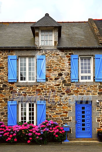 Typical country house with blue shutters in Brittany, France Typical country house with blue shutters in Brittany, France