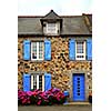 Typical country house with blue shutters in Brittany, France