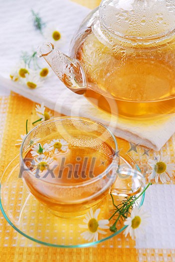 Teacup and teapot with soothing chamomile tea Teacup and teapot with soothing chamomile tea
