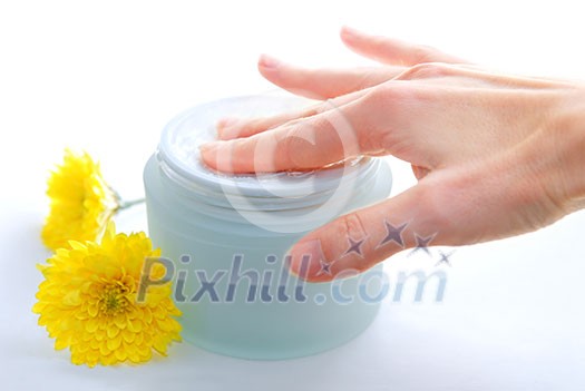 Woman's hand touching a creame in open jar Woman's hand touching a creame in open jar