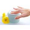 Woman's hand touching a creame in open jar