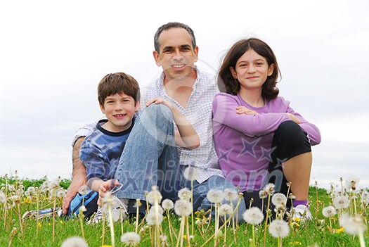 Portrait of a happy family of three on green grass Portrait of a happy family of three on green grass