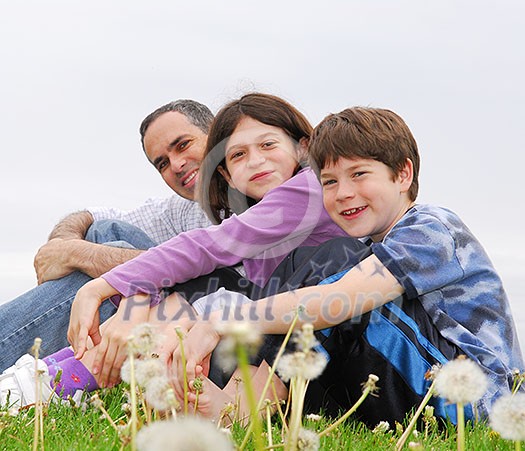 Portrait of a happy family of three on green grass Portrait of a happy family of three on green grass