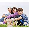 Portrait of a happy family of three on green grass