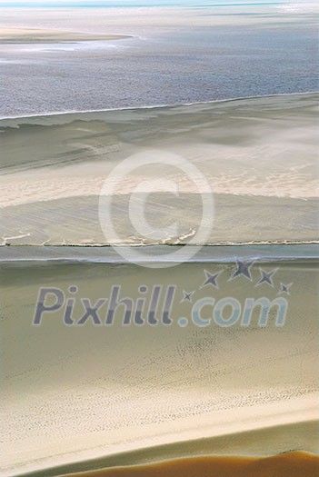 Aerial view of Atlantic ocean at low tide near Mont Saint Michel abbey in France. Background. Aerial view of Atlantic ocean at low tide near Mont Saint Michel abbey in France. Background.