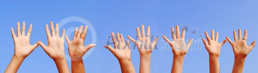 Row of hands with open palms on blue sky background Row of hands with open palms on blue sky background
