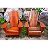 Two solid wood patio chairs and natural stone landscaping