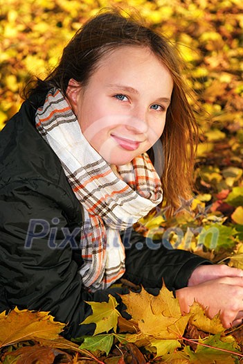 Portrait of a beautiful teenage girl in a fall park with fallen leaves Portrait of a beautiful teenage girl in a fall park with fallen leaves