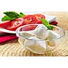 Bocconcini cheese, basil and sliced tomatoes - ingredients of traditional italian cuisine