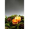 Christmas arrangement of burning candles and green spruce branches, background