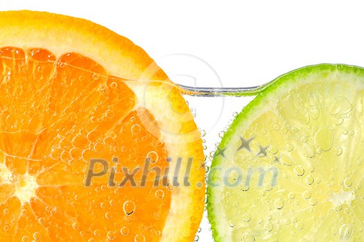 Orange and lime slices in water with air bubbles on white background Orange and lime slices in water with air bubbles on white background