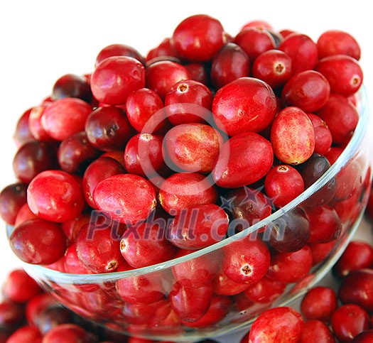 Fresh red cranberries in a glass bowl on white background Fresh red cranberries in a glass bowl on white background
