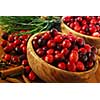 Fresh red cranberries in wooden bowls with spices and pine branches