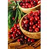 Fresh red cranberries in wooden bowls with spices and pine branches