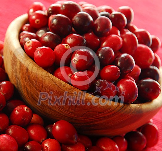 Fresh red cranberries in a wooden bowl Fresh red cranberries in a wooden bowl