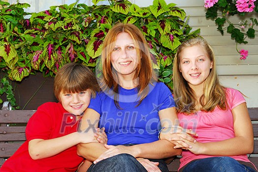 Family of mother and children sitting in front of their house Family of mother and children sitting in front of their house