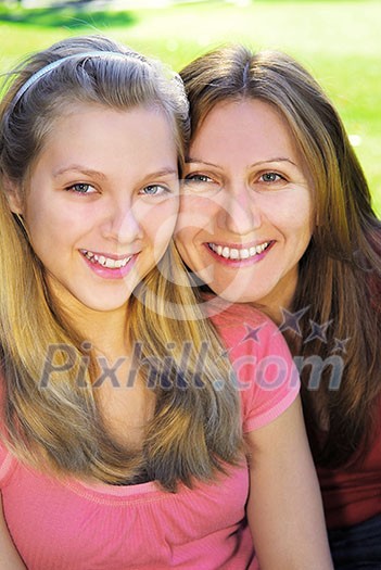 Portrait of a smiling mother and teenage daughter in summer park Portrait of a smiling mother and teenage daughter in summer park