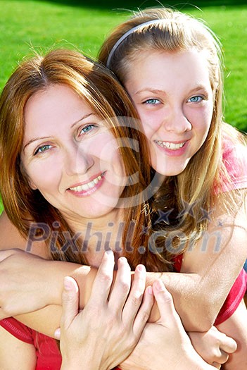Portrait of a smiling mother and teenage daughter in summer park Portrait of a smiling mother and teenage daughter in summer park