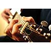 Hands of a person playing an acoustic guitar close up