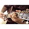 Hands of a person playing an acoustic guitar close up