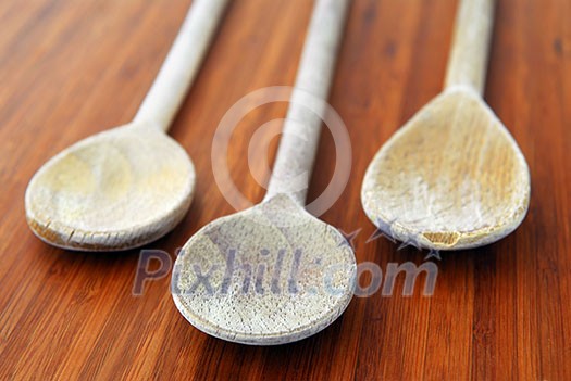 Old wooden cooking spoons on a cutting board in a kitchen Old wooden cooking spoons on a cutting board in a kitchen