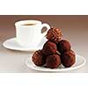Gourmet chocolate truffles on a plate with a cup of coffee