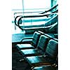 Row of chairs and escalator inside an airport