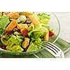 Fresh caesar salad with croutons and bacon bits served in a glass bowl