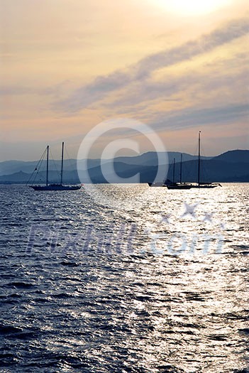 Anchored sailboats at sunset at Mediterranean coast Anchored sailboats at sunset at Mediterranean coast