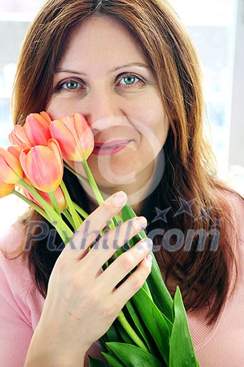 Smiling mature woman holding bouquet of flowers Smiling mature woman holding bouquet of flowers