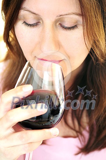 Mature woman holding a glass of red wine Mature woman holding a glass of red wine