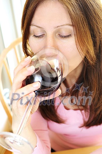 Mature woman holding a glass of red wine Mature woman holding a glass of red wine