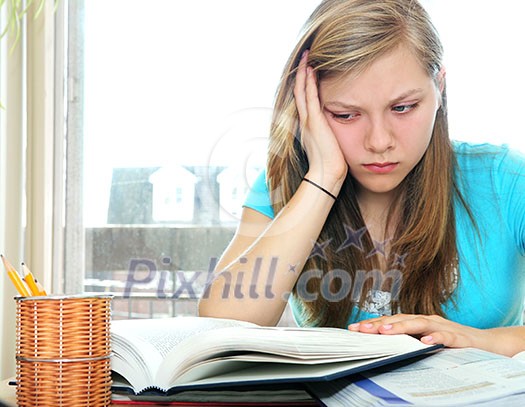 Teenage girl studying with textbooks looking unhappy Teenage girl studying with textbooks looking unhappy