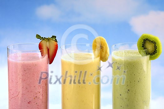 Assorted fruit and berry smoothies on blue sky background Assorted fruit and berry smoothies on blue sky background