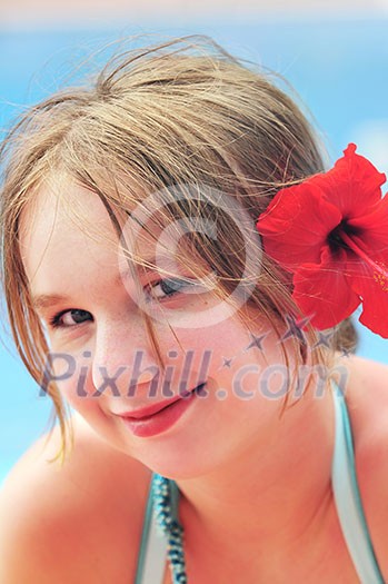 Portrait of a young girl on tropical beach with red flower Portrait of a young girl on tropical beach with red flower