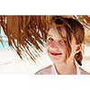Portrait of a young girl on tropical beach under umbrella