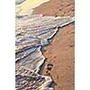 Tropical sandy beach with footprints and ocean wave