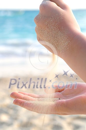 Hands pouring fine sand on a beach Hands pouring fine sand on a beach