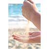 Hands pouring fine sand on a beach