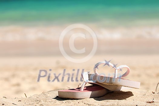 Flipflops on a sandy ocean beach - vacation concept Flipflops on a sandy ocean beach - vacation concept