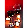 Two wineglasses with red wine at candlelight