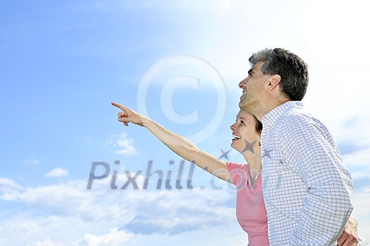 Mature romantic couple of baby boomers looking at the sky Mature romantic couple of baby boomers looking at the sky