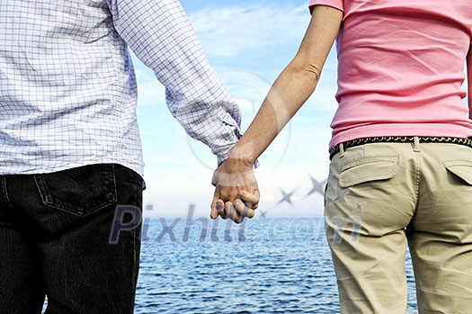 Mature romantic couple holding hands on the beach Mature romantic couple holding hands on the beach