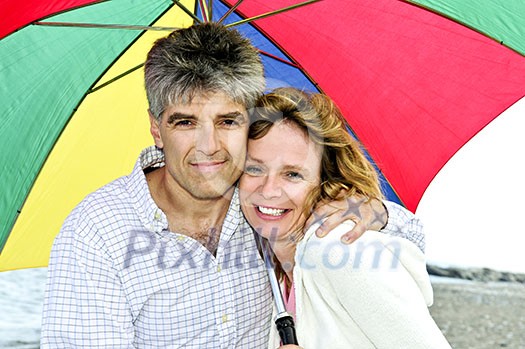 Portrait of happy mature couple under umbrella Portrait of happy mature couple under umbrella